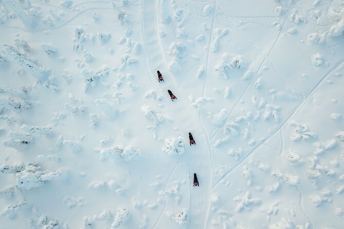 Lappish Lunch Break -Snowmobiling, ice fishing and tasty food - Following the guide across Finnish snow